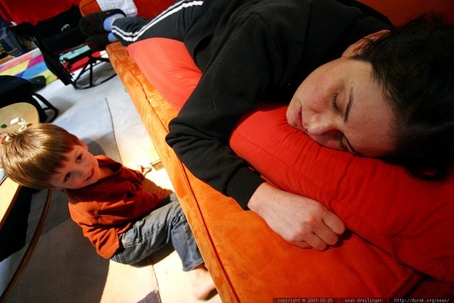 Child looks at exhausted mother